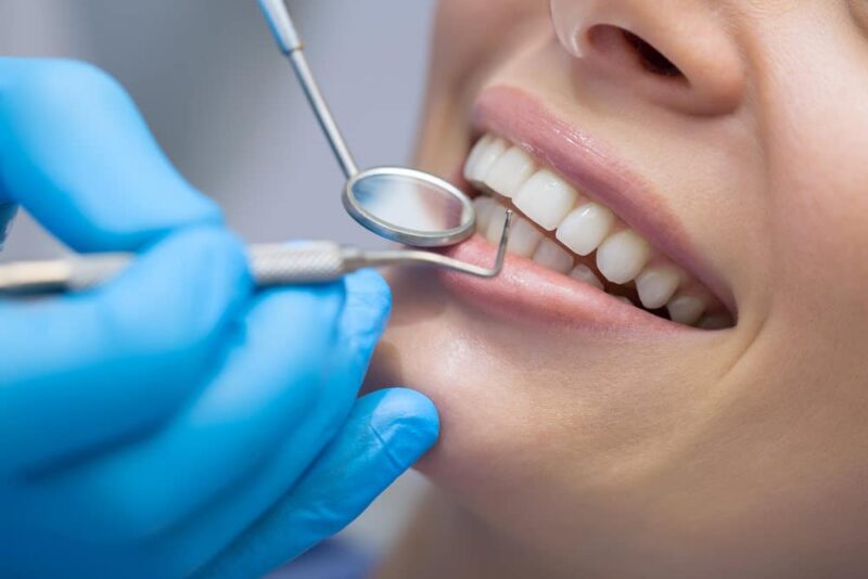Dentist,examining,a,patient's,teeth,in,the,dentist.